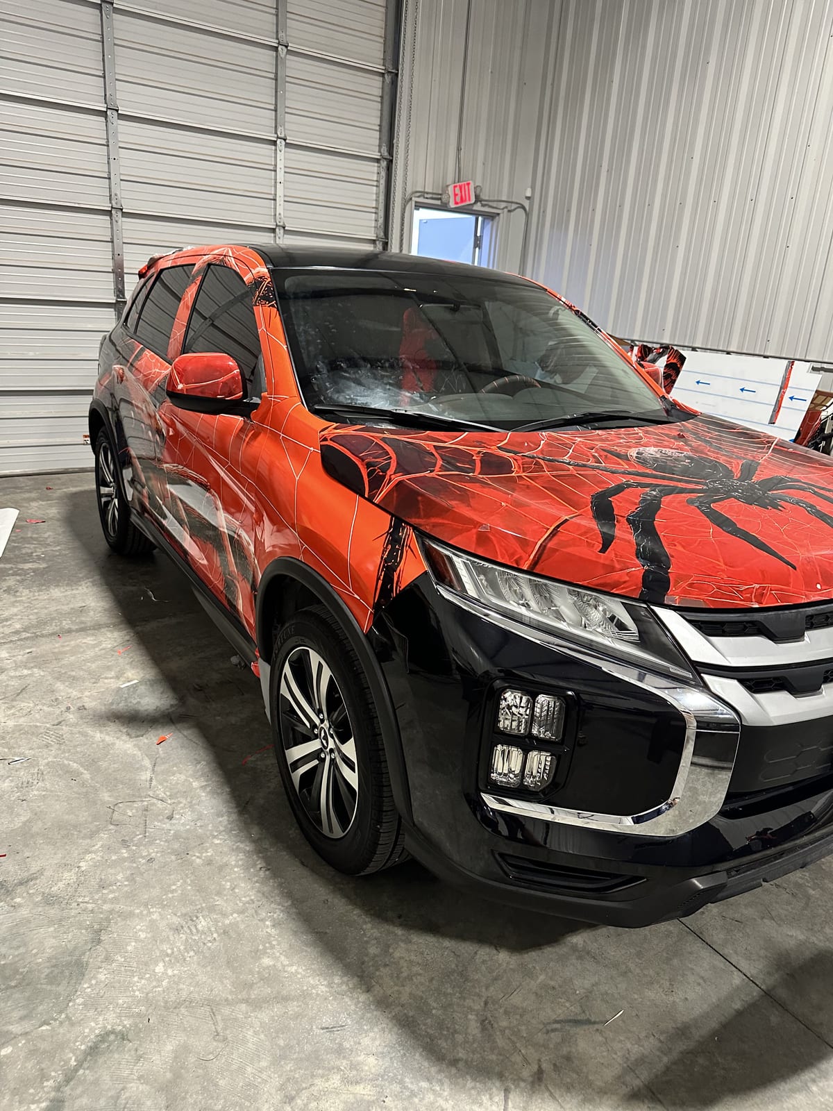 The finished spider-web art wrap, black spider across the hood